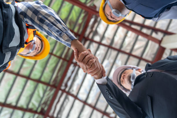 istock Construction teamwork success, Construction worker and Civil Engineer shake hand in construction site. View from below. 2165106669