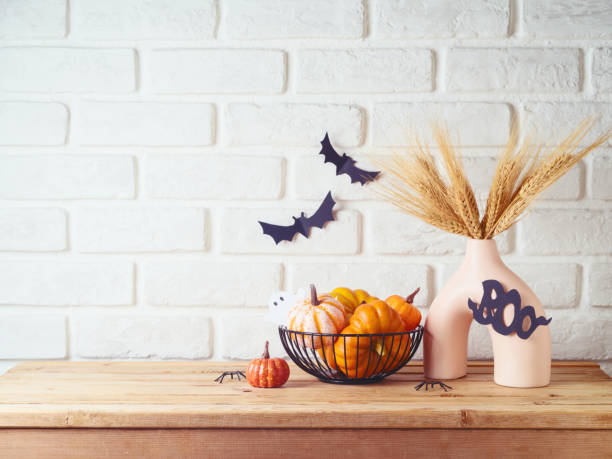 istock Halloween background with modern vase and decoration on wooden table over brick wall. Empty space for product display 2165107275