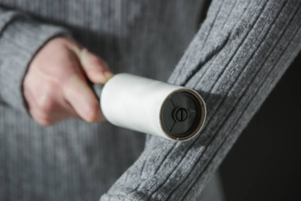 istock Hair remover roller. Woman using reusable clothes lint roller cleaner. 2165113927