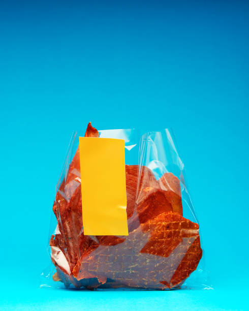istock Open package of meat jerky with yellow label with empty space on bright blue background 2165122691