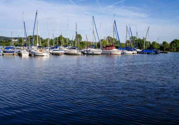 Copenhagen, Denmark - September 2, 2025: Sailboats docked at marina pier with tall masts and mirrored water in Copenhagen harbor under calm weather
