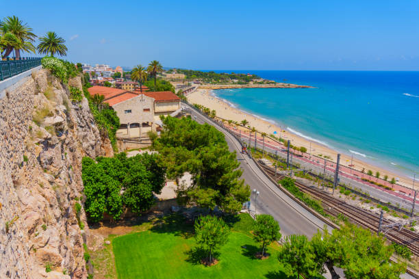 Coastal view showcasing lush greenery and sandy beach area of Tarragona, Spain.