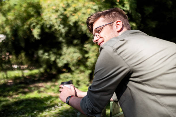 Young man standing outside with a coffee mug