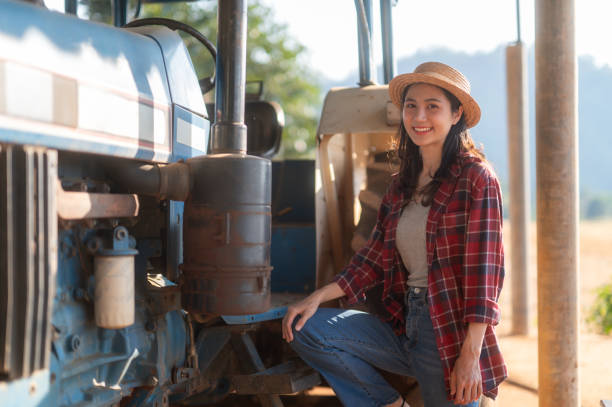istock Proud female farmer standing with tractor 2165126888