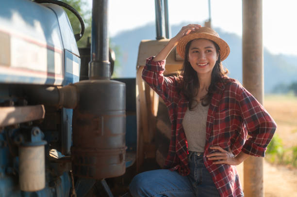 istock Proud female farmer standing with tractor 2165126985