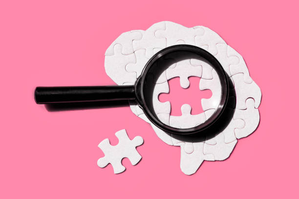 istock Brain Puzzle with Magnifying Glass on Vibrant Pink Background 2165128030