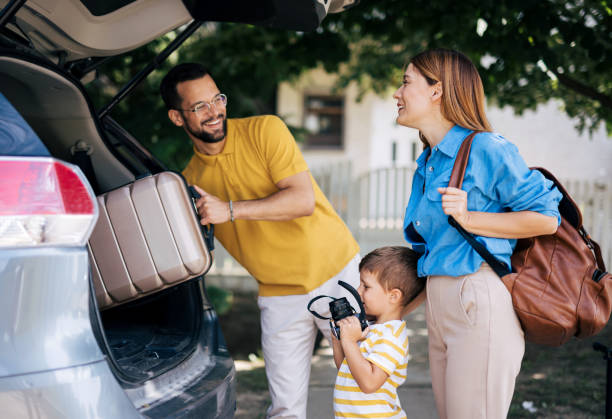istock Family teamwork loading car trunk with vacation luggage 2165132802