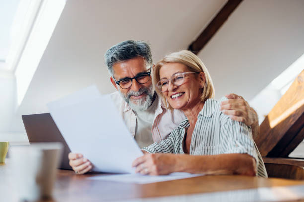 Happy Senior Couple Reading Documents Together at Home