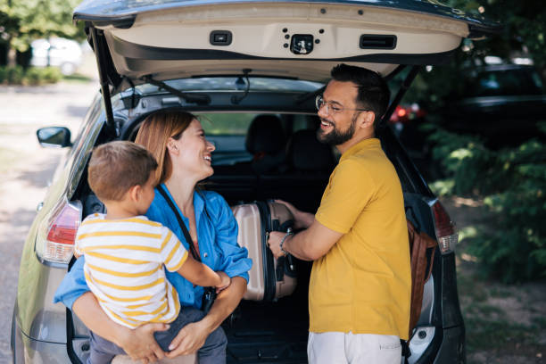 istock Family smiling while packing car for a trip 2165133069
