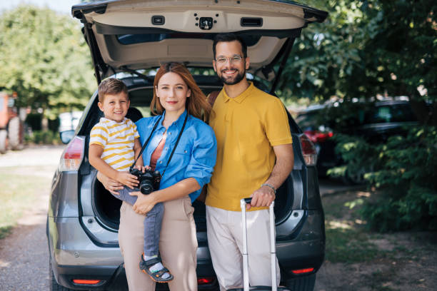 istock Family ready for a trip poses by packed car 2165133075