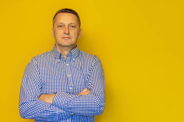 istock Middle aged man on the yellow background 2165145833