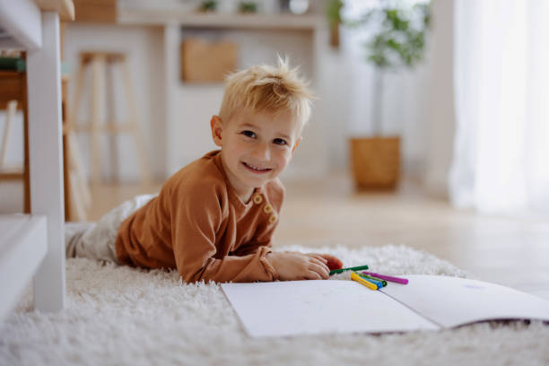 istock Little Boy Drawing With Felt-tip Pen on Floor at Home 2165149915