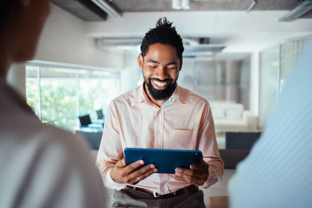 istock Smiling Businessman Using Digital Tablet In Modern Office 2165154358