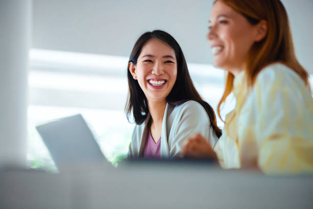 Businesswomen Smiling and Sharing a Light Moment at Work