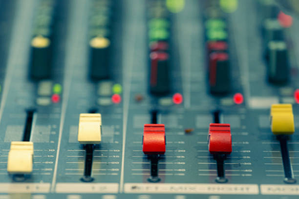 Professional analog audio mixing console with knobs and slides for music and recording equipment,Blurred background and close-up.