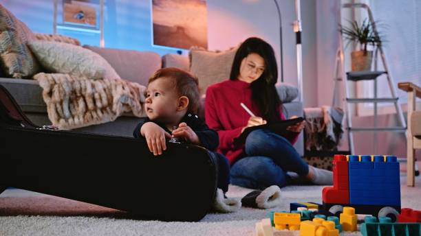 istock Family evening. Mom works while baby boy plays. 2165161388