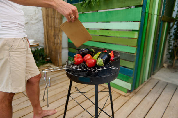 istock Man grilling fresh vegetables on a charcoal barbecue in a backyard garden 2165165016