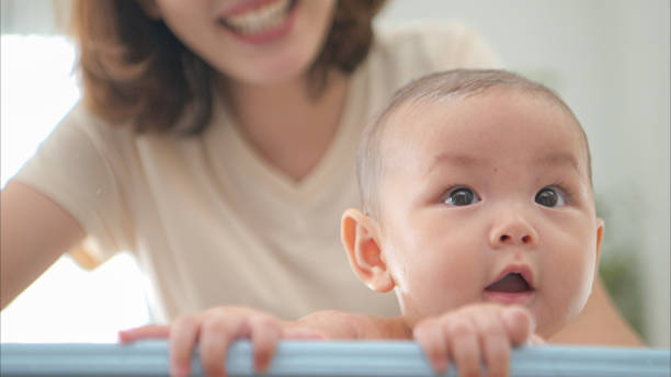istock A tiny child enjoys taking a bath in a baby bathtub with mom 2165166579