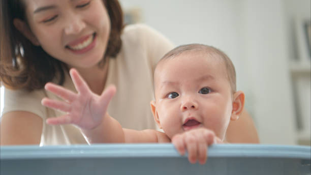 istock A tiny child enjoys taking a bath in a baby bathtub with mom 2165166648