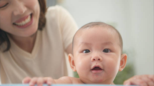istock A tiny child enjoys taking a bath in a baby bathtub with mom 2165166800