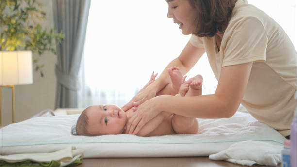 istock A tiny child smiles happily on the bed waiting for mother apply powder and put on clothes after taking a bath 2165166830
