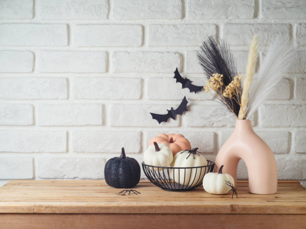 istock Halloween background with modern vase and decoration on wooden table over brick wall. Empty space for product display 2165167584