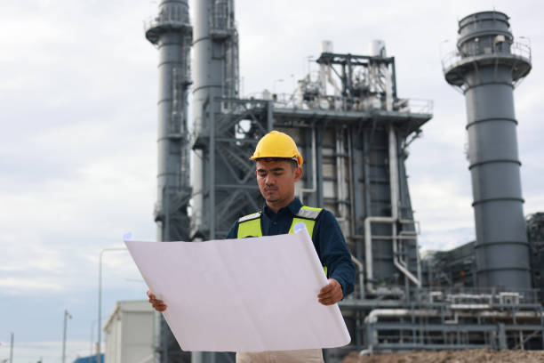 istock Construction project leader working on blueprint drawing at factory site 2165172344