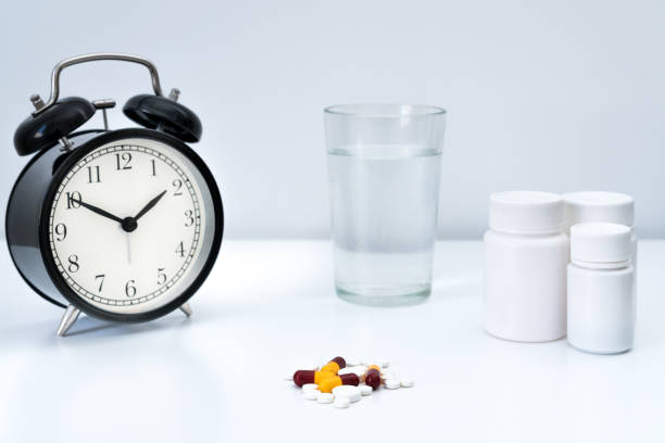 istock Pills, capsules and alarm clock on white background 2165174658
