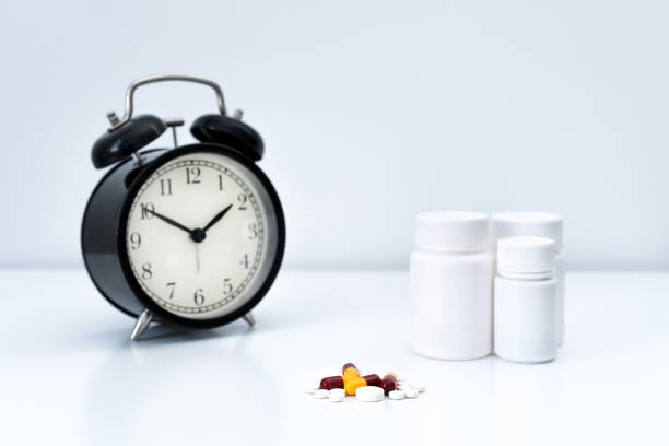 istock Pills, capsules and alarm clock on white background 2165174660