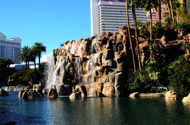 LAS VEGAS, NEVADA USA - 13 DEC 2019: People looking at Bellagio fountain musical performance at night. Contrast silhouettes and glowing dancing splashing water. Entertainment show in gambling city.