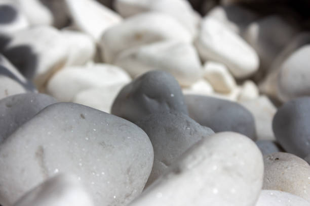 Presentation for product. Stone podium and pebbles on light grey background, top view. Space for text