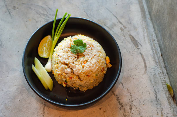 istock Crab fried rice in a black plate, decorated and served on a wooden table, 2165194182