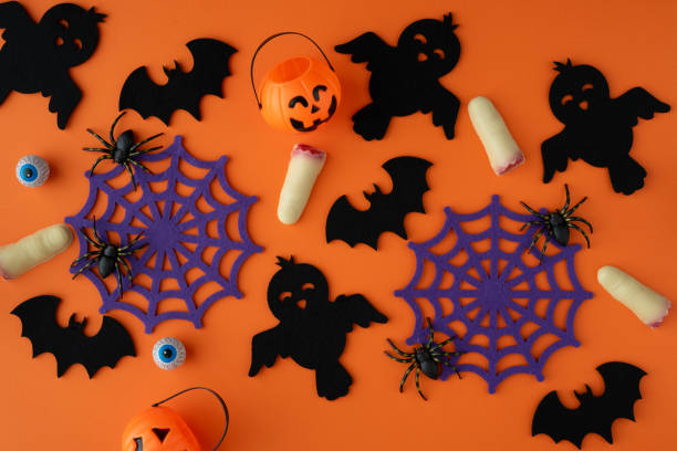 istock Bats, ghosts, pumpkins, spider webs and chocolate fingers on an orange background. 2165196551