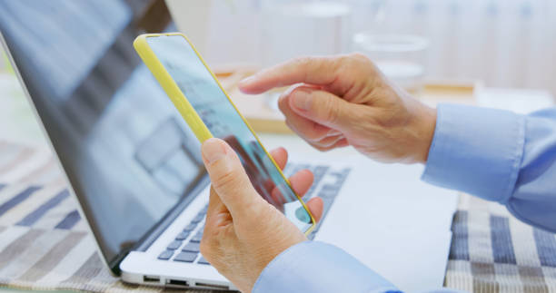 istock closeup elderly hand laptop mobile 2165196564