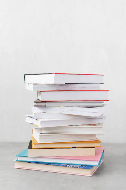 istock Stack of books with colorful bookbindings against white wall with copy space, book lover 2165198854