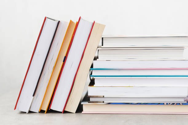 istock Stack of books with colorful bookbindings against white wall with copy space, book lover 2165198873