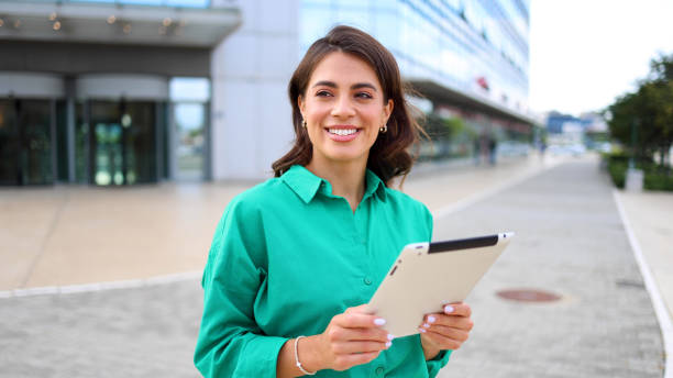 istock Professional woman using a tablet on the sidewalk 2165199235