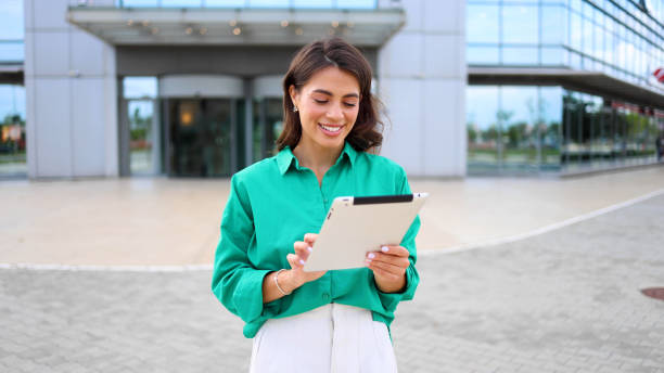 istock Professional woman using a tablet on the sidewalk 2165199239