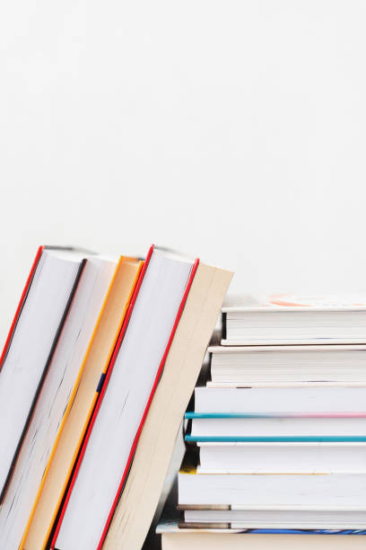 istock Stack of books with colorful bookbindings against white wall with copy space, book lover 2165199475
