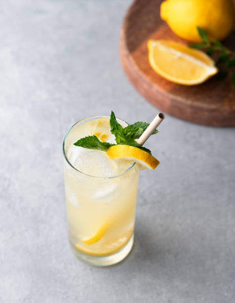 istock Freshness mojito drink with lemon, mint and ice. Citrus lemonade on a blue background with wooden board and fruits. 2165203454