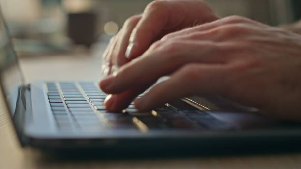 istock Man hands typing laptop keyboard searching internet in office desk close up. 2165211465