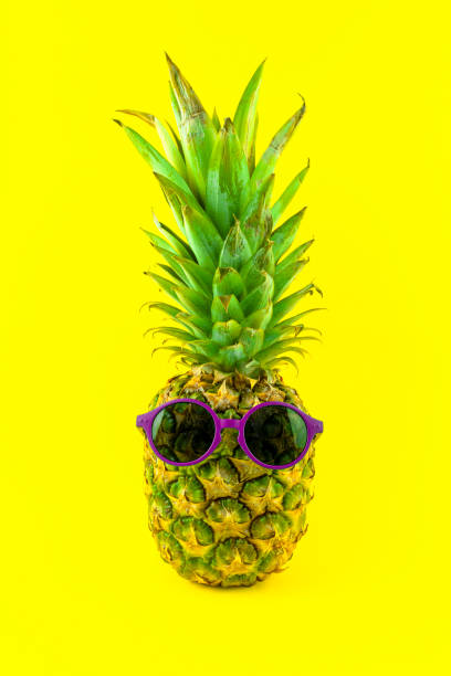 istock Pineapple with sunglasses isolated on yellow background 2165213093