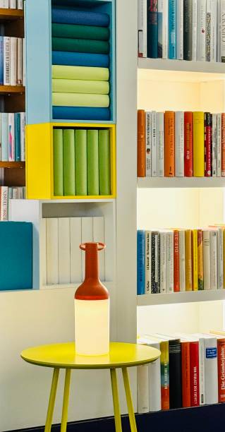 istock Yellow table with lamp standing at the bookshelves 2165215249