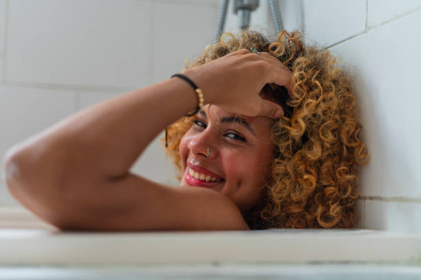 istock Beautiful woman enjoys taking a relaxing bath in her tub while visiting her hotel 2165215921
