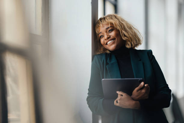 istock Smiling Businesswoman Holding Tablet in Relaxed Office Setting 2165220536