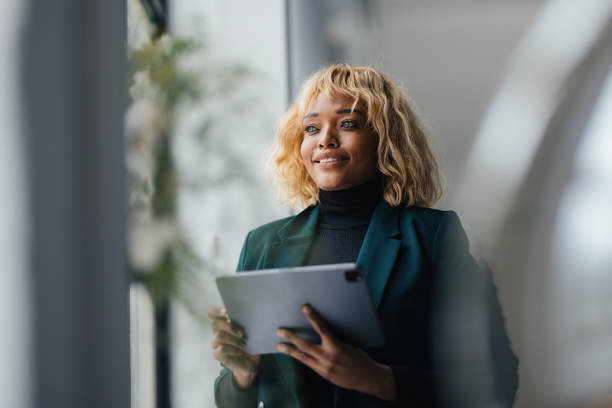 istock Confident Businesswoman Holding Tablet in Modern Office Setting 2165220540