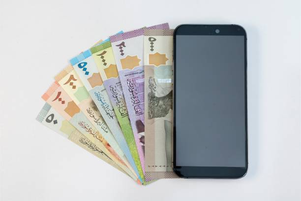 istock Syria banknotes with smart phone isolated on white background 2165225187