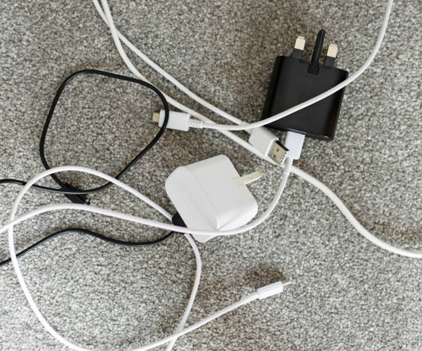 istock Tangled electrical wires and adaptor plugs on a grey carpet 2165226242