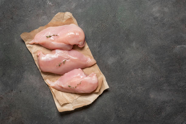 istock Raw chicken fillet on a dark background. Top view, flat lay, copy space. 2165227491
