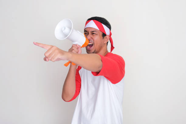 istock Indonesian man screaming using megaphone and pointing forward with excited 2165228298